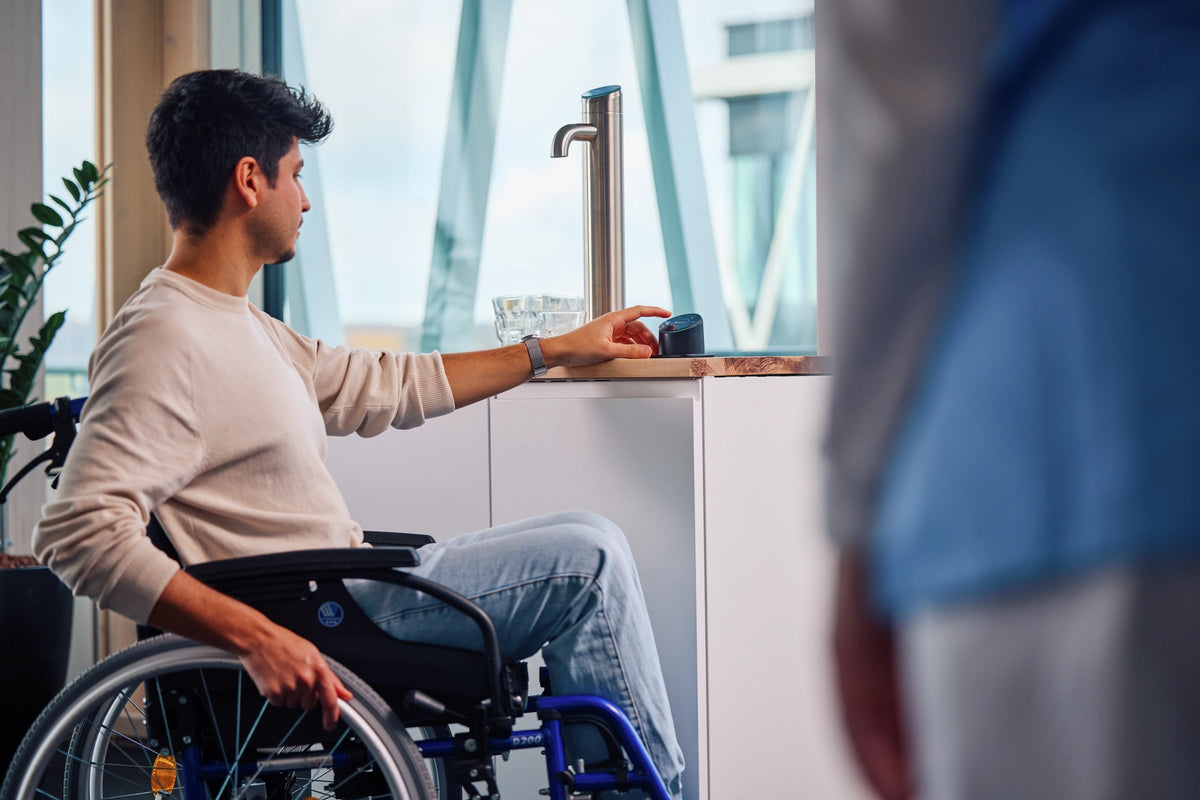 Persona in sedia a rotelle che utilizza il pannello Easy Access in un ufficio 